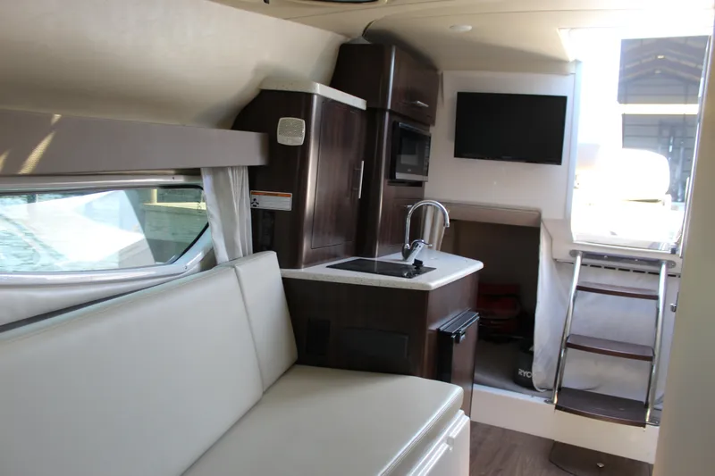 Slide: The Image of Interior of 2018 Regal 28 Express boat with kitchenette, seating, and TV. - 31