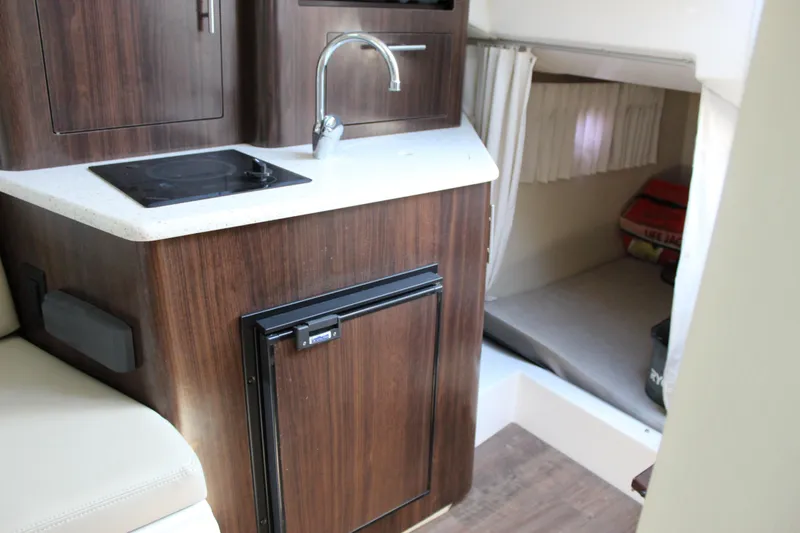 Slide: The Image of 2018 Regal 28 Express boat interior with kitchenette and cozy sleeping area. - 35
