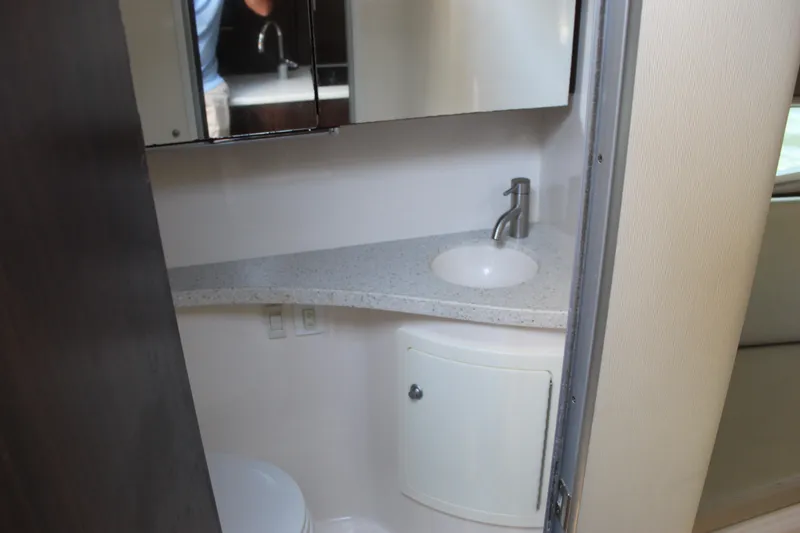 Slide: The Image of 2018 Regal 28 Express boat bathroom with sink, mirror, and storage cabinet. - 41