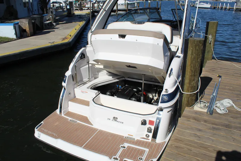 Slide: The Image of 2018 Regal 28 Express boat docked, engine compartment open, showcasing sleek design and functionality. - 46
