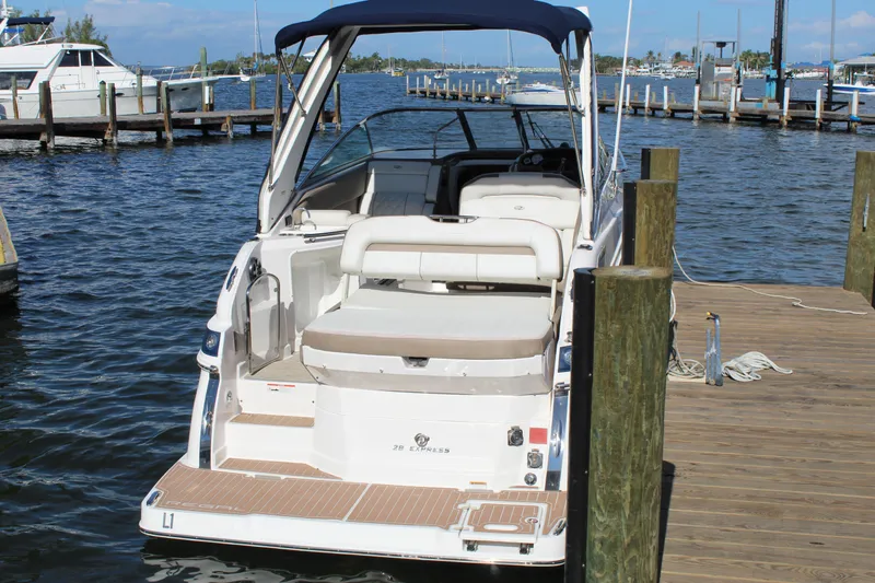 Slide: The Image of 2018 Regal 28 Express boat docked at marina, featuring spacious seating and sleek design. - 7