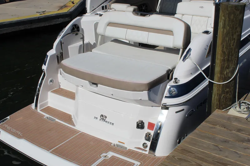 Slide: The Image of 2018 Regal 28 Express boat docked, featuring spacious seating and elegant design. - 8