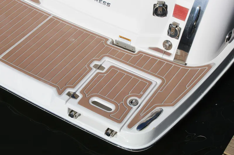 Slide: The Image of 2018 Regal 28 Express boat deck with brown non-slip surface and chrome fittings. - 9