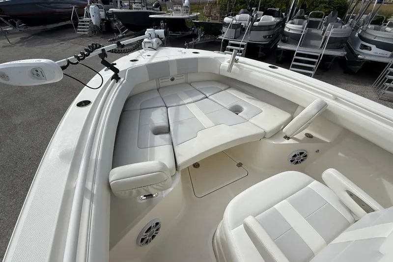 Slide: The Image of 2022 Mako 234 Center Console boat interior with cushioned seating and modern design. - 12