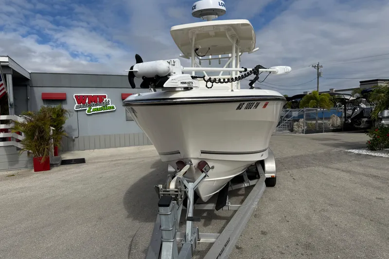 Slide: The Image of 2022 Mako 234 Center Console boat on trailer at dealership, under cloudy sky. - 4