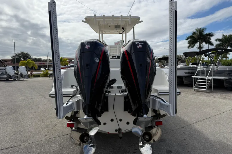 Slide: The Image of 2022 Mako 234 Center Console boat with dual outboard motors, docked outdoors. - 8
