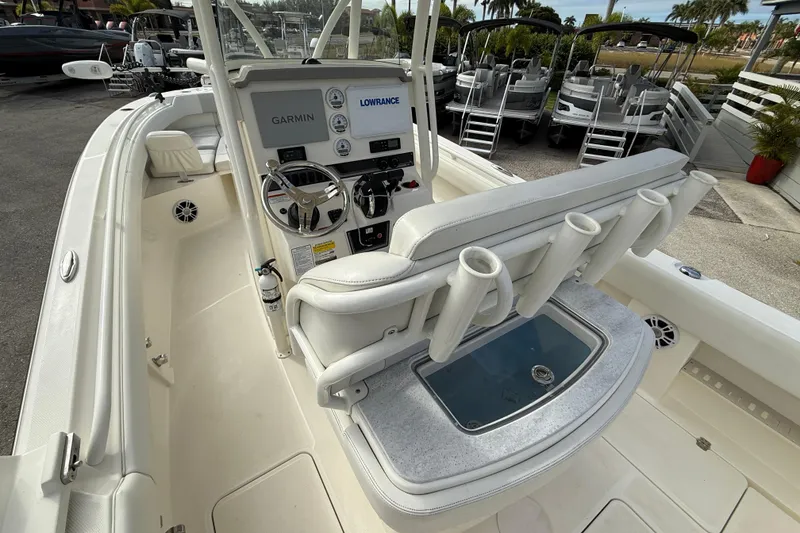 Slide: The Image of 2022 Mako 234 Center Console boat interior with steering wheel and rod holders. - 11