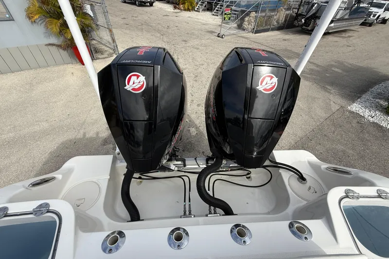 Slide: The Image of 2022 Mako 234 Center Console with dual Mercury outboard engines, docked outdoors. - 25