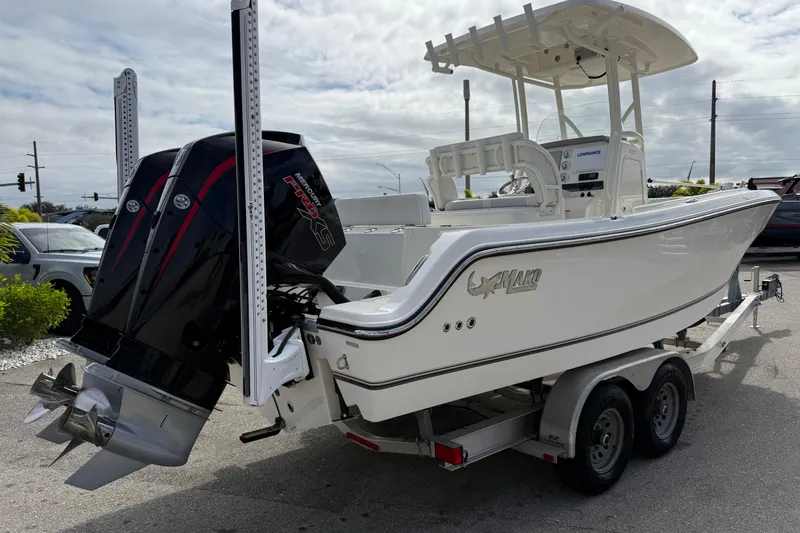 Slide: The Image of 2022 Mako 234 Center Console boat on trailer with dual outboard engines. - 6