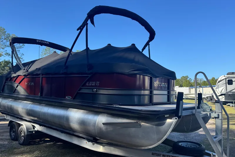Slide: The Image of 2023 Sylvan L5 CLZ pontoon boat on trailer, covered and parked outdoors. - 12