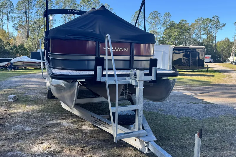Slide: The Image of 2023 Sylvan L5 CLZ pontoon boat on trailer, covered, in outdoor storage area. - 13