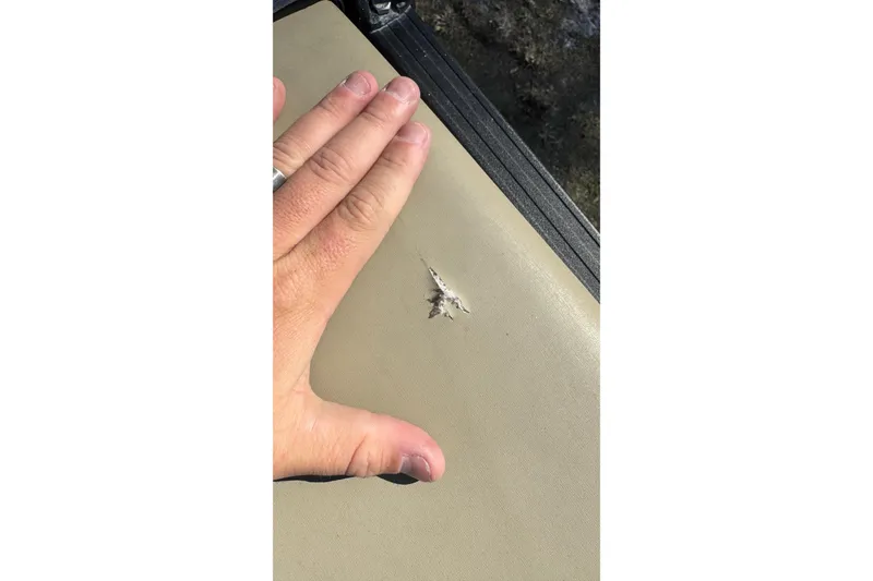 Slide: The Image of Hand showing damage on 2023 Sylvan L5 CLZ boat upholstery. - 23