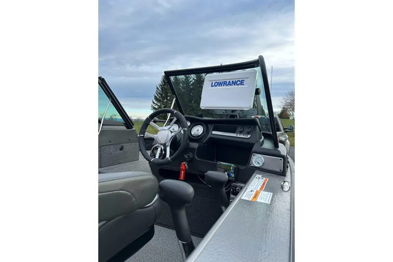 Slide: The Image of 2021 Lund 2175 Pro-V boat interior with steering wheel and Lowrance navigation system. - 10
