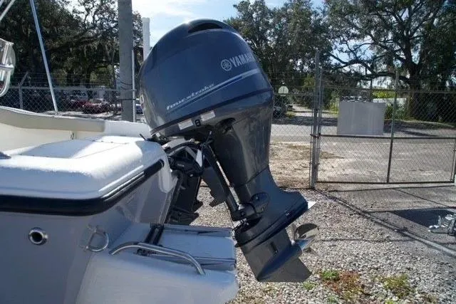 Slide: The Image of 2026 Key West 179 FS boat with Yamaha outboard motor in a fenced area. - 11