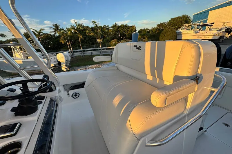 Slide: The Image of 2022 SeaVee 340Z boat interior with white seating and steering wheel, under a clear sky. - 12