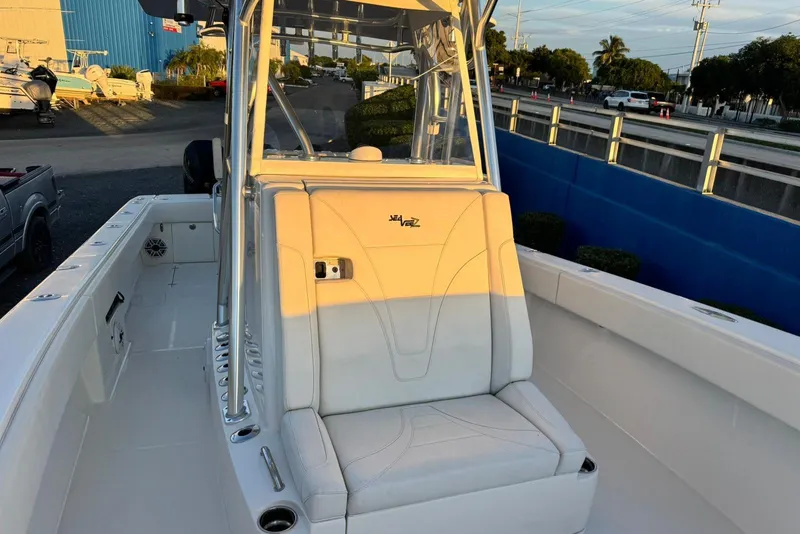 Slide: The Image of 2022 SeaVee 340Z boat interior with seating and console, docked outdoors. - 15