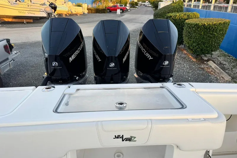 Slide: The Image of 2022 SeaVee 340Z boat with triple Mercury engines, docked in a marina. - 6