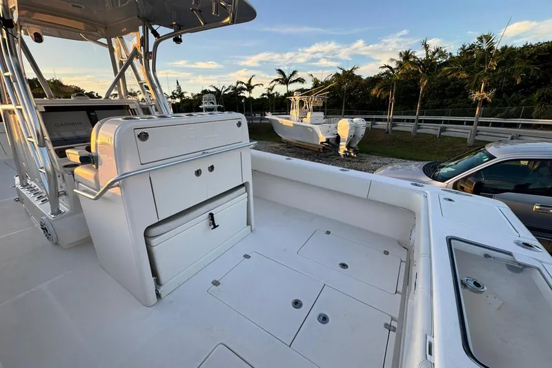 Slide: The Image of 2022 SeaVee 340Z boat interior with console and storage, parked near palm trees. - 8