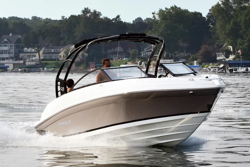 The Image of 2019 Rinker Q3 OB boat cruising on a lake with scenic background. - 0