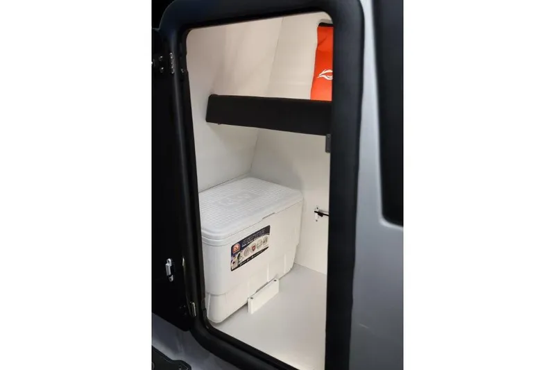 Slide: The Image of Storage compartment of 2019 Rinker Q3 OB boat with cooler and life jacket. - 13