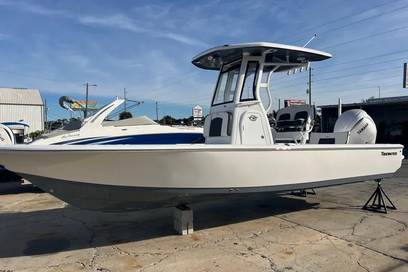 Slide: The Image of 2026 Tidewater 2410 Bay Max boat with Yamaha engine, displayed outdoors on a sunny day. - 2