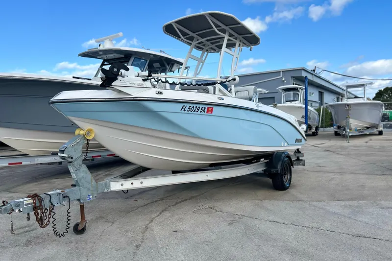 The Image of 2019 Yamaha Boats 190 FSH Sport on trailer, parked outdoors under blue sky. - 1
