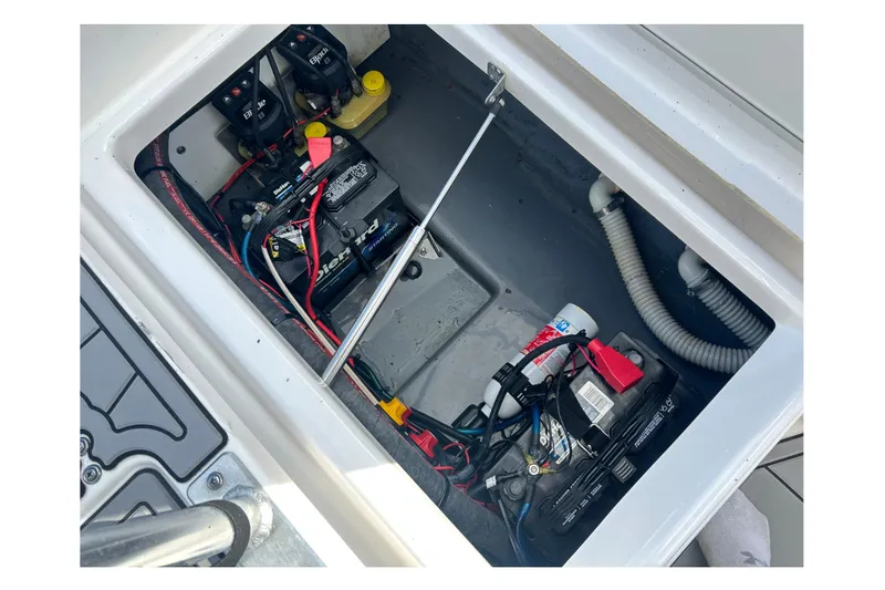 Slide: The Image of 2019 Yamaha Boats 190 FSH Sport battery compartment with wiring and components. - 14