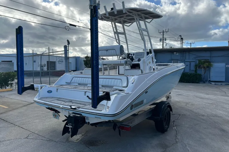 Slide: The Image of 2019 Yamaha Boats 190 FSH Sport on trailer, parked outdoors under cloudy sky. - 23