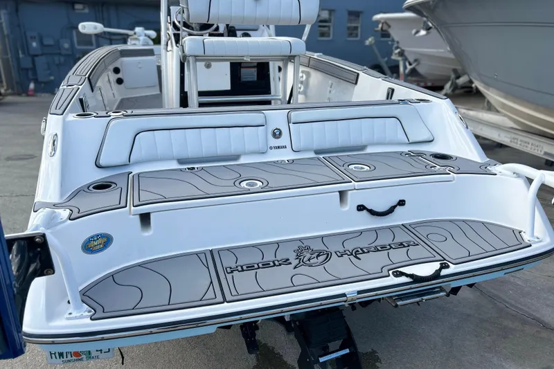 Slide: The Image of 2019 Yamaha Boats 190 FSH Sport, rear view, docked, featuring custom deck design. - 7