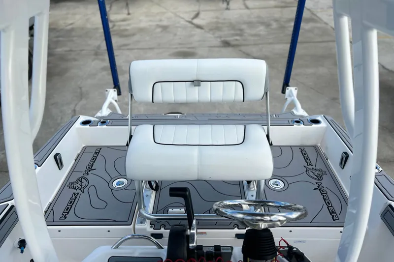 Slide: The Image of 2019 Yamaha Boats 190 FSH Sport interior with white seating and steering wheel. - 9