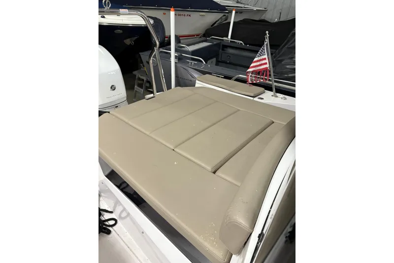 Slide: The Image of 2022 Axopar 28 CABIN boat with beige seating and American flag. - 17