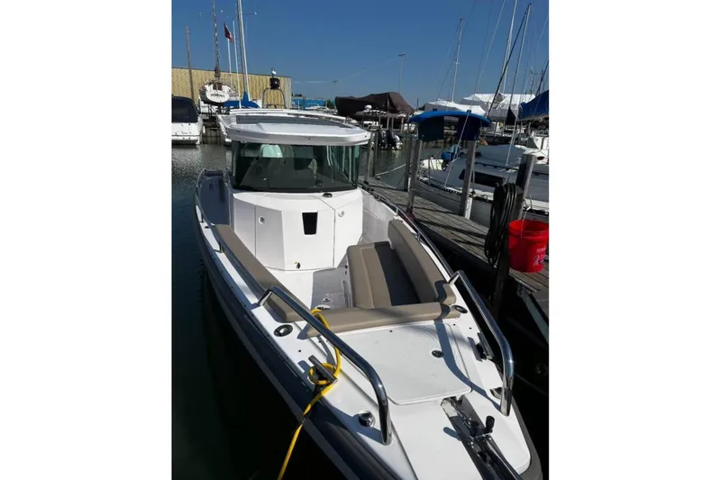 Slide: The Image of 2022 Axopar 28 CABIN boat docked at marina, featuring sleek design and spacious seating. - 2