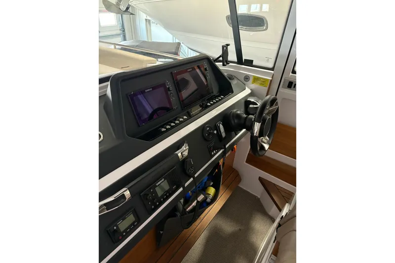 Slide: The Image of 2022 Axopar 28 CABIN boat dashboard with modern controls and navigation screens. - 24