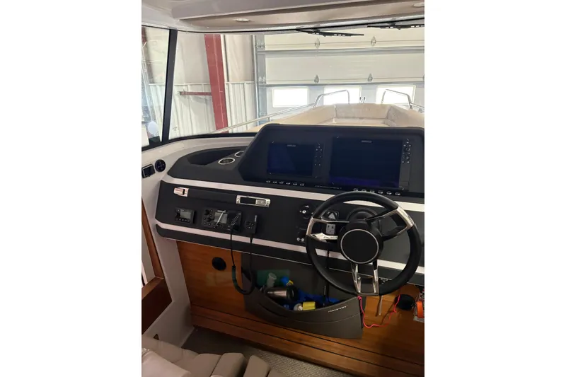 Slide: The Image of 2022 Axopar 28 CABIN boat interior with modern dashboard and steering wheel. - 26