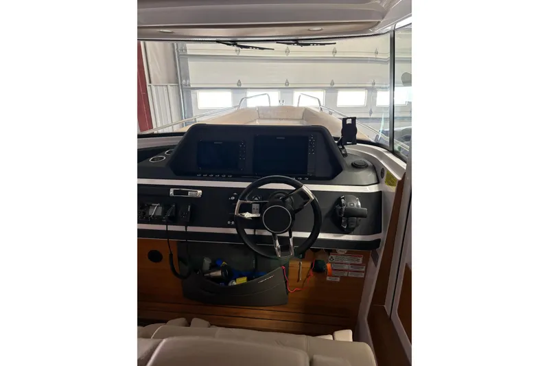 Slide: The Image of Interior view of 2022 Axopar 28 CABIN boat dashboard with steering wheel and controls. - 27