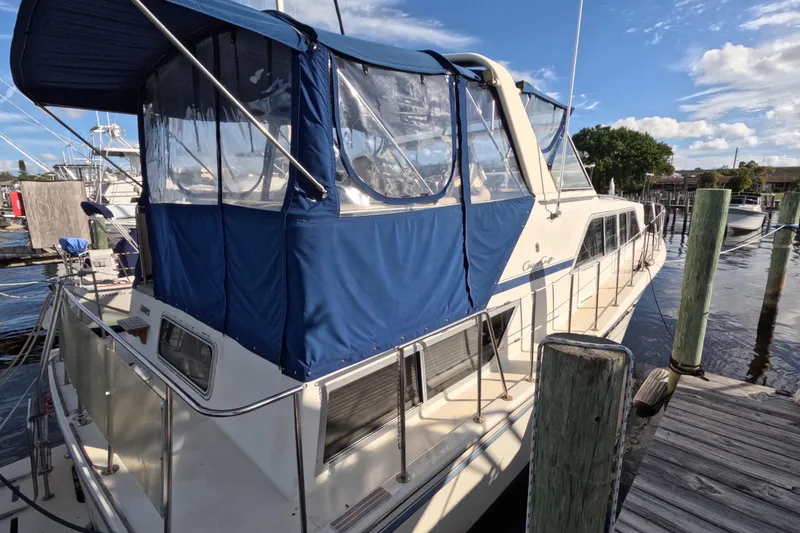 Slide: The Image of 1985 Chris-Craft 381 Catalina yacht docked with blue canopy under clear sky. - 10