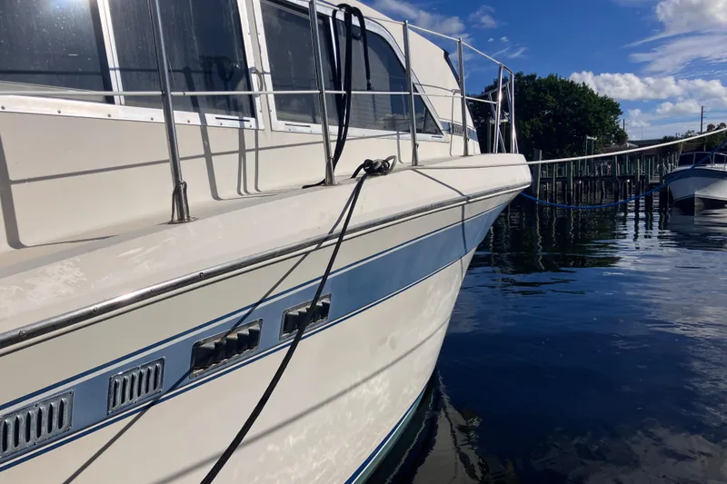 Slide: The Image of 1985 Chris-Craft 381 Catalina yacht docked on calm water under blue sky. - 12
