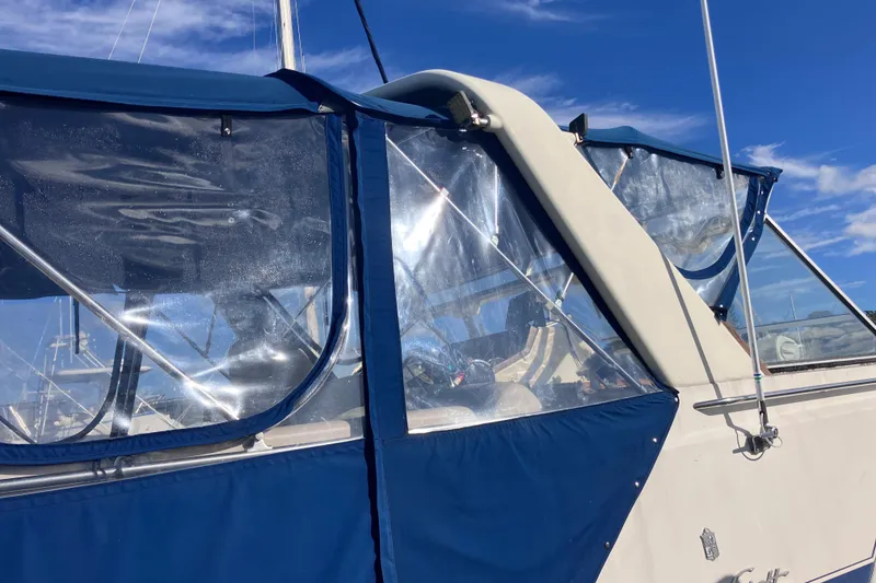 Slide: The Image of 1985 Chris-Craft 381 Catalina boat with blue canopy under clear sky. - 13