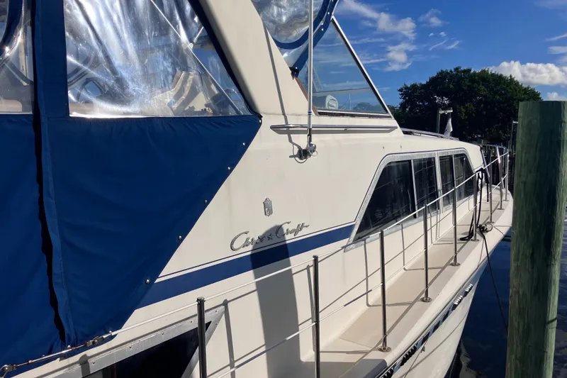 Slide: The Image of 1985 Chris-Craft 381 Catalina yacht docked, featuring blue canopy and sleek design. - 14