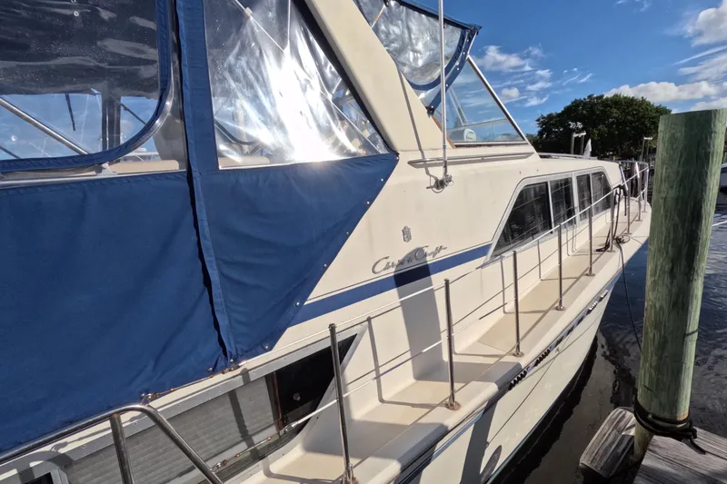 Slide: The Image of 1985 Chris-Craft 381 Catalina yacht docked, featuring blue canopy and sleek design. - 15