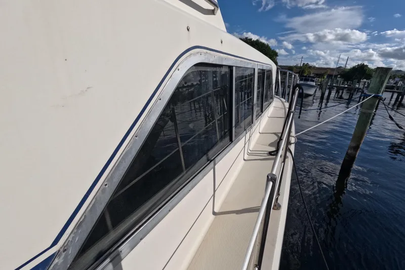 Slide: The Image of 1985 Chris-Craft 381 Catalina yacht docked, showcasing side view and windows. - 17