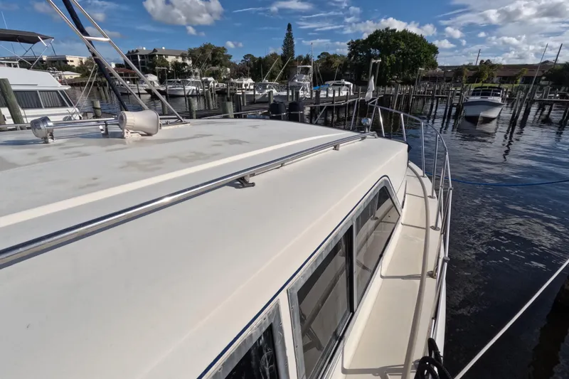 Slide: The Image of 1985 Chris-Craft 381 Catalina yacht docked at a marina under a clear blue sky. - 18