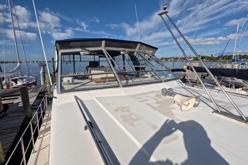 Slide: The Image of 1985 Chris-Craft 381 Catalina yacht docked, showcasing deck and cabin under clear blue sky. - 20