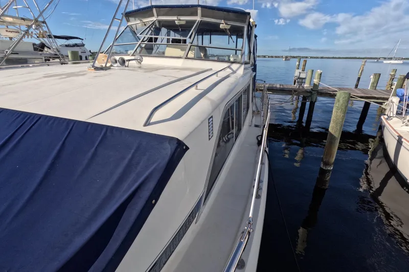 Slide: The Image of 1985 Chris-Craft 381 Catalina yacht docked at marina under clear blue sky. - 22