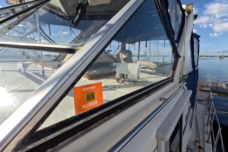 Slide: The Image of 1985 Chris-Craft 381 Catalina boat with Florida registration sticker, docked by the water. - 25