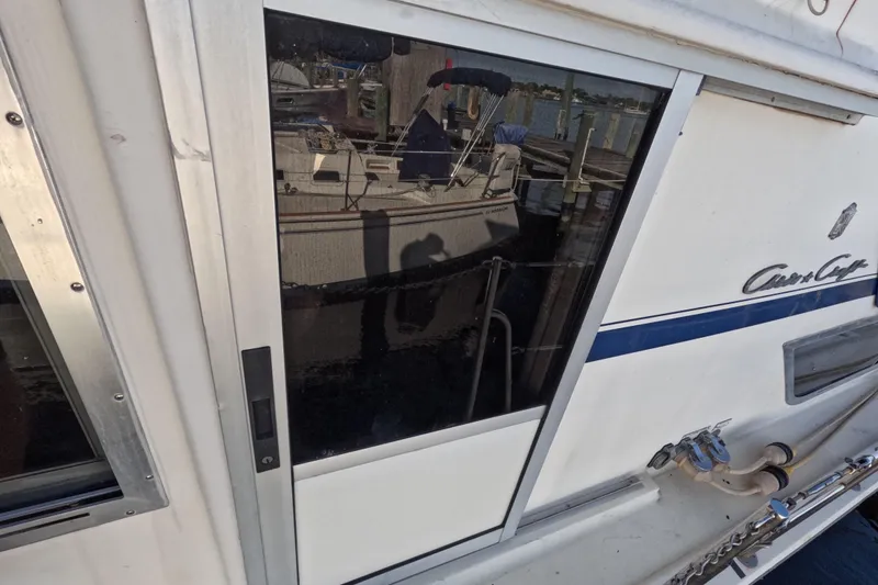 Slide: The Image of 1985 Chris-Craft 381 Catalina boat with reflective windows and dockside view. - 26