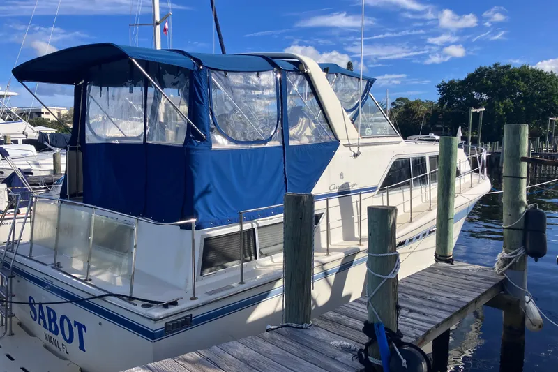 Slide: The Image of 1985 Chris-Craft 381 Catalina docked, featuring blue canopy and white hull. - 9