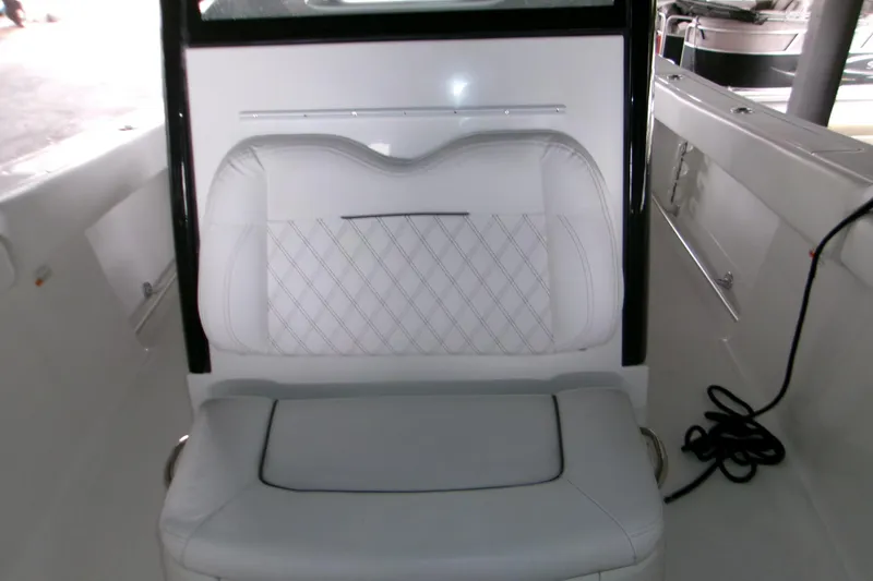 Slide: The Image of 2023 Sportsman Open 282 Center Console boat interior with white cushioned seating. - 9