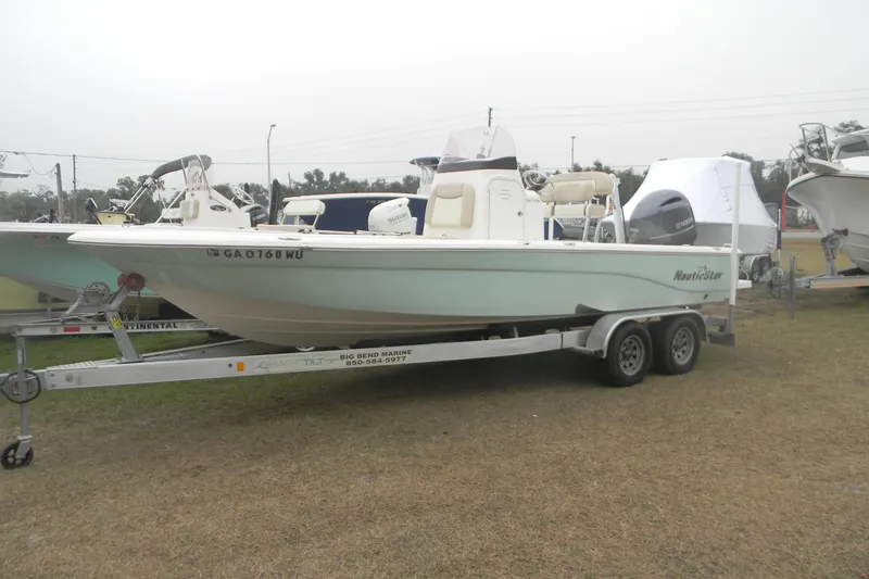 Slide: The Image of 2018 NauticStar 227 XTS boat on trailer, displayed outdoors. - 4