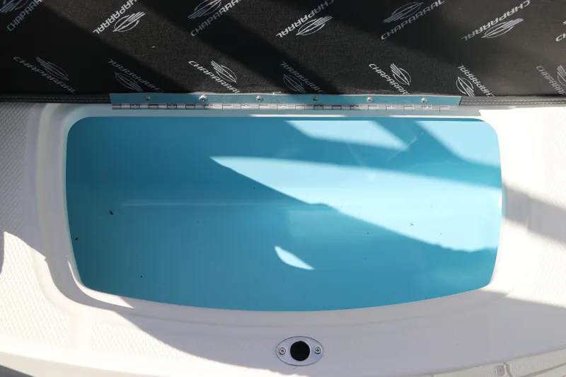 Slide: The Image of 2026 Chaparral 21 SSi OB boat storage compartment with Chaparral branding. - 19